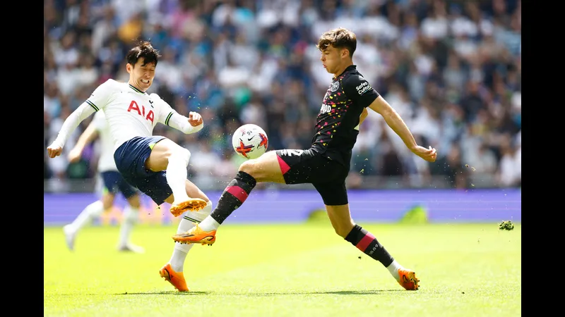Cầu thủ Tottenham với sự quyết tâm chuyền bóng qua hậu vệ Brentford